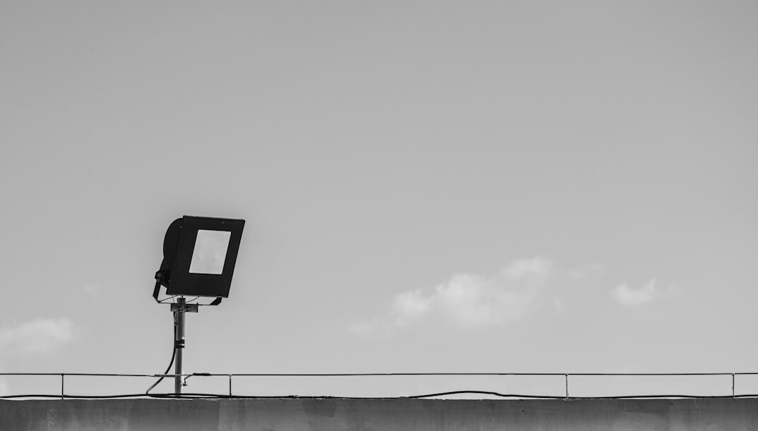 Broadcast studio camera on a pedestal facing a news desk